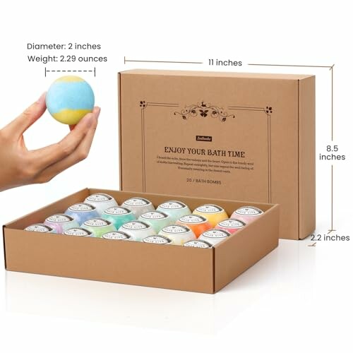 A hand holding a bath bomb with a box of assorted bath bombs.