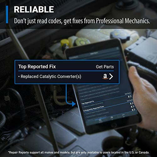 Mechanic using a tablet for car diagnostics and repair advice.