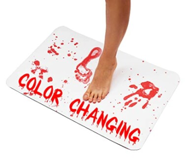 Foot on color-changing bath mat with red footprints.