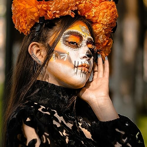 Person with Day of the Dead face paint and orange flower headdress.