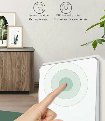 Finger touching a circular target on a screen with furniture in the background.
