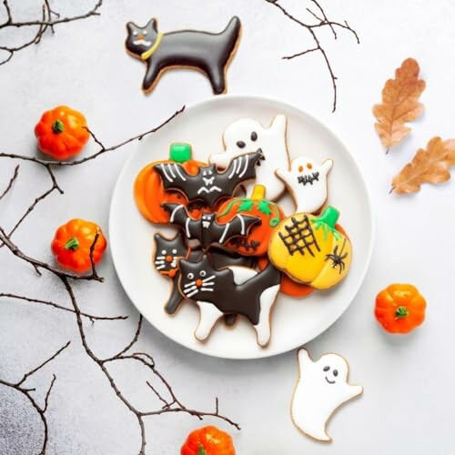 Plate of Halloween cookies shaped like cats, bats, ghosts, and pumpkins.