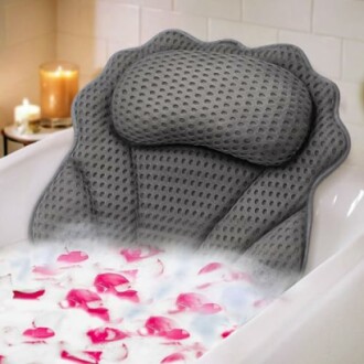 Gray bath pillow with rose petals in a bathtub.