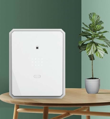 White air purifier on a wooden table beside a potted plant with green leaves.