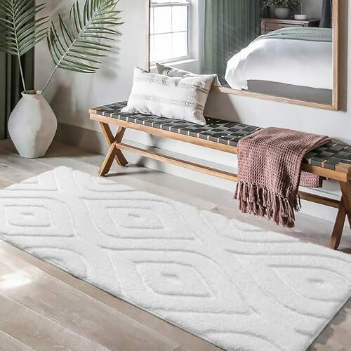 Modern bedroom with bench, decorative rug, and plant