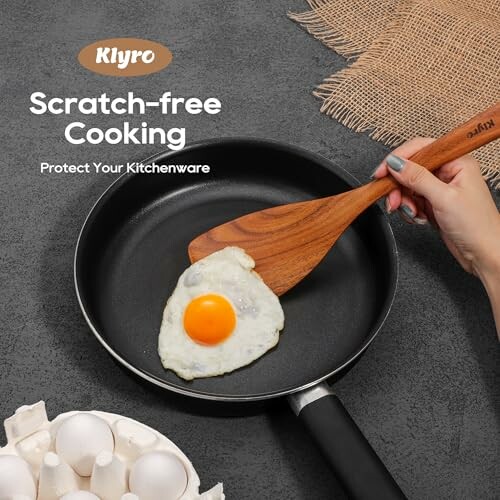 Nonstick frying pan with egg and wooden spatula.