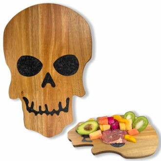 Skull-shaped cutting board with sliced fruits and avocado.