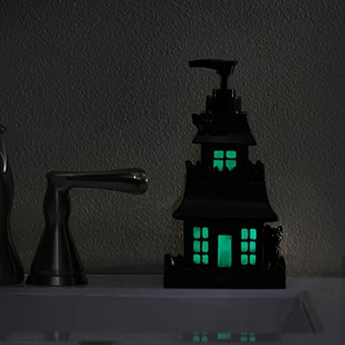 Glowing haunted house soap dispenser on bathroom counter