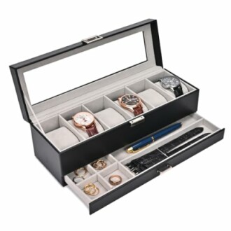 Open black storage box with watches, rings, pen, and straps.