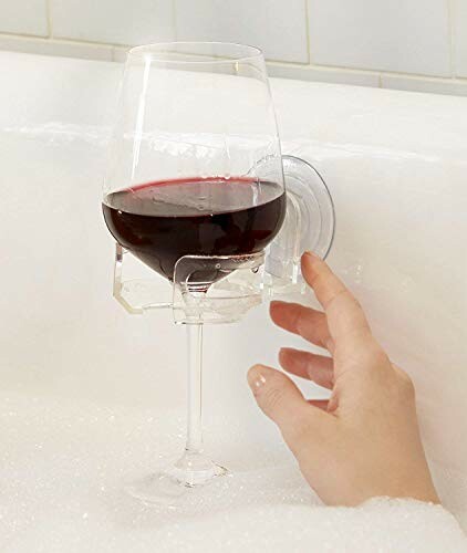 Hand reaching for wine glass in bath holder