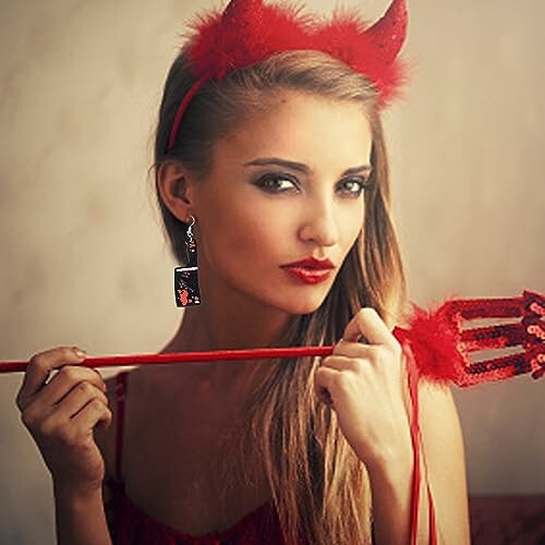 Woman in devil costume with red horns and pitchfork