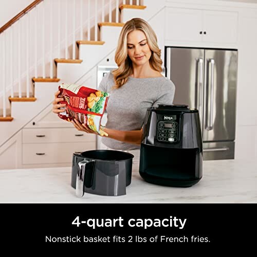 Woman preparing to use a Ninja air fryer in the kitchen.